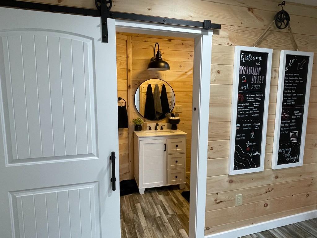 New River Hideaway bathroom through barn door with welcome chalkboards