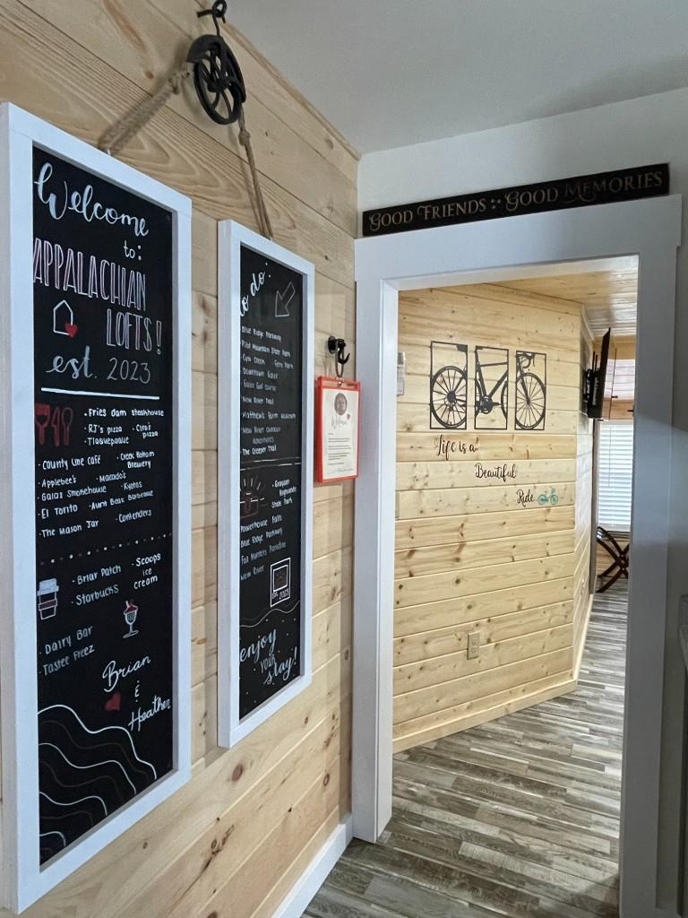 New River Hideaway hallway with guest welcome and local tips chalkboards